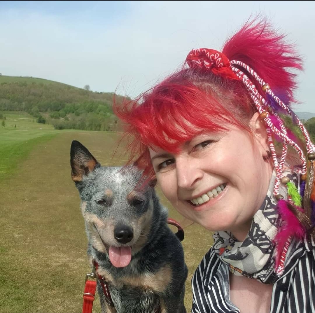Vicki Cook with a dog in a field.