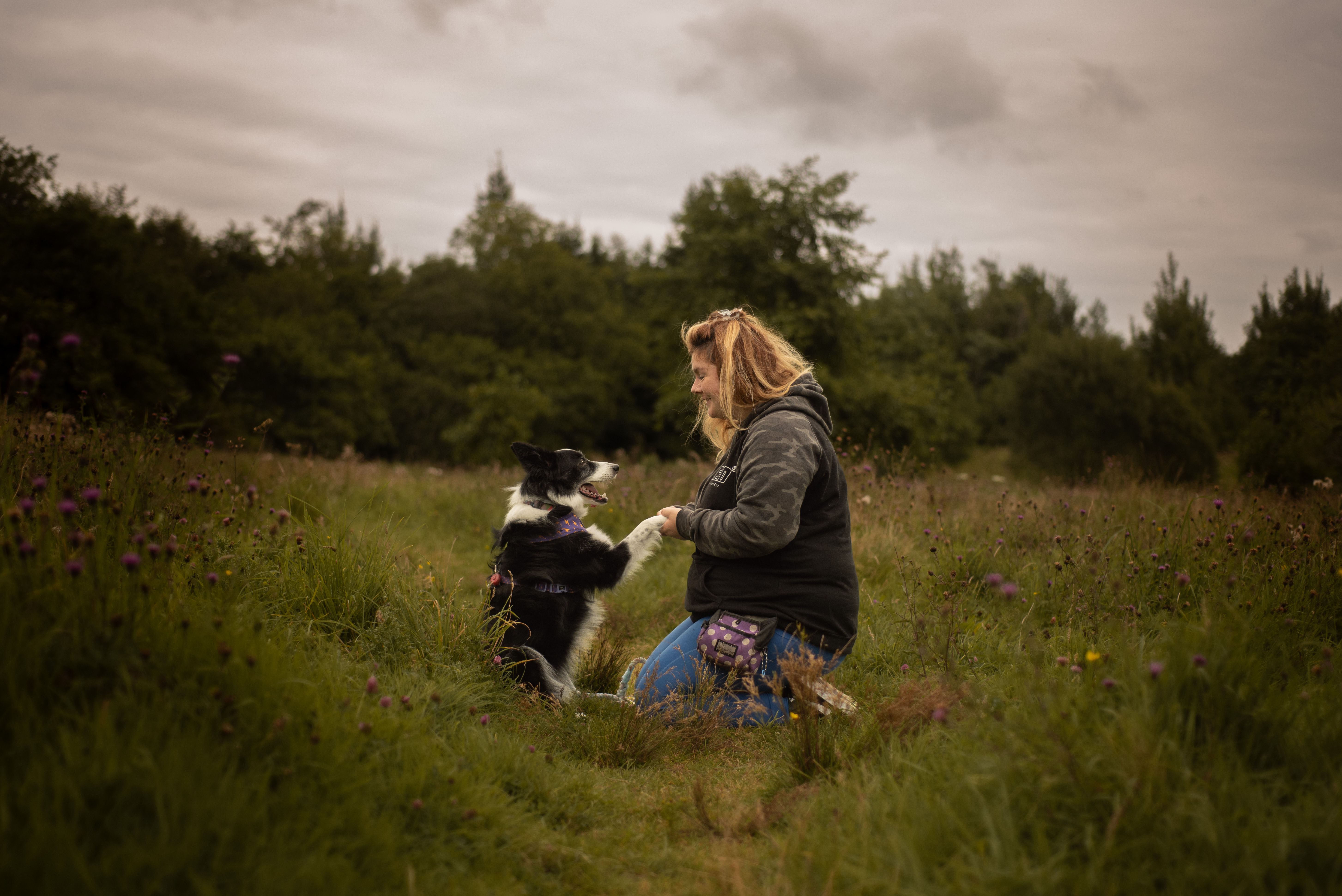 llana and her dog meet in a field.